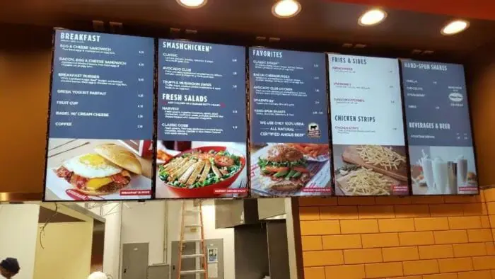 Backlit menu boards above a restaurant counter