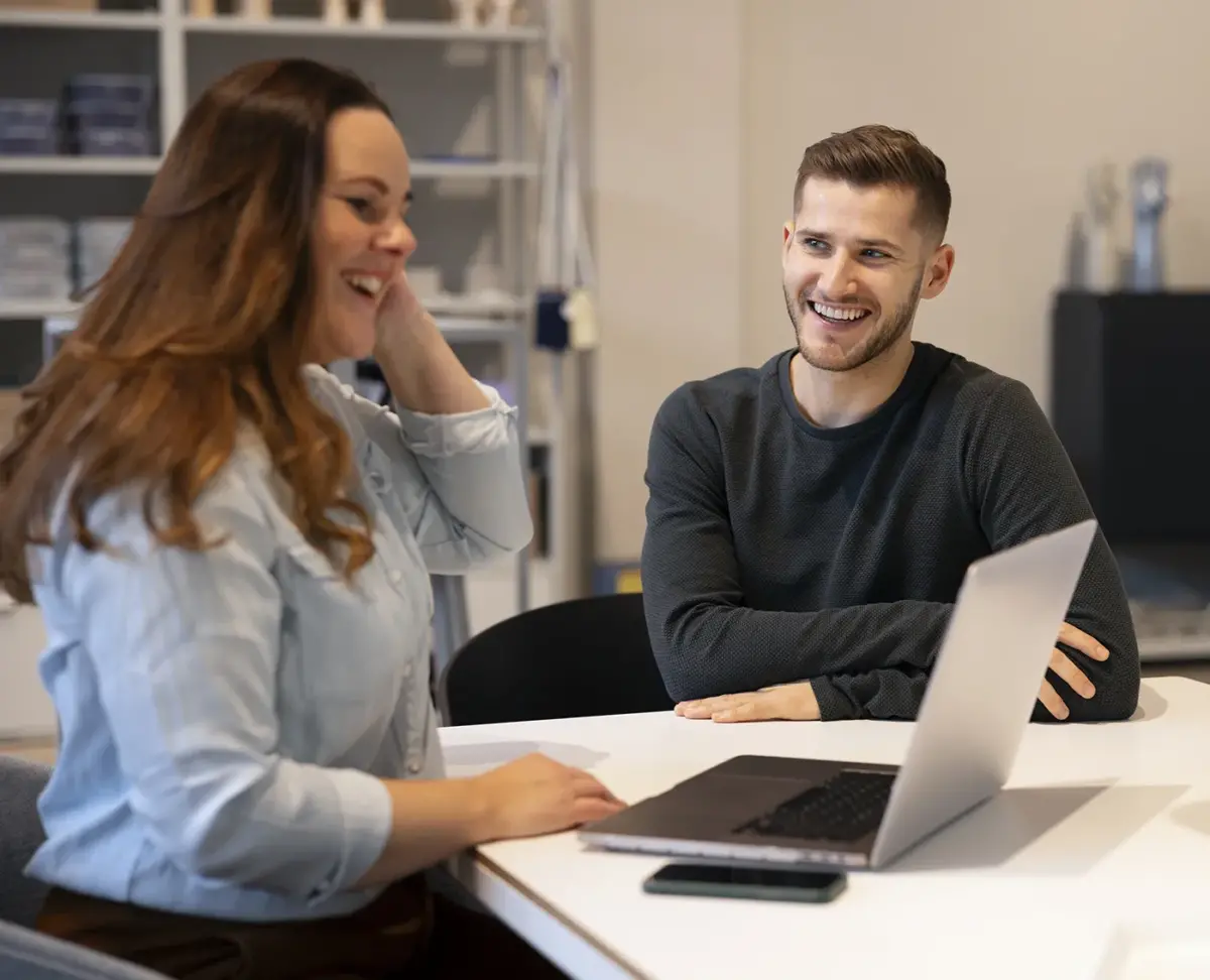 Two people reviewing a website project on a laptop